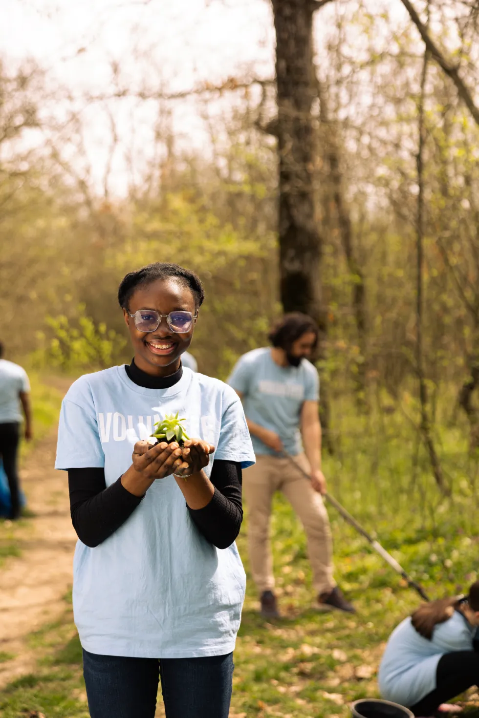 Volunteers planting trees outdoors.
